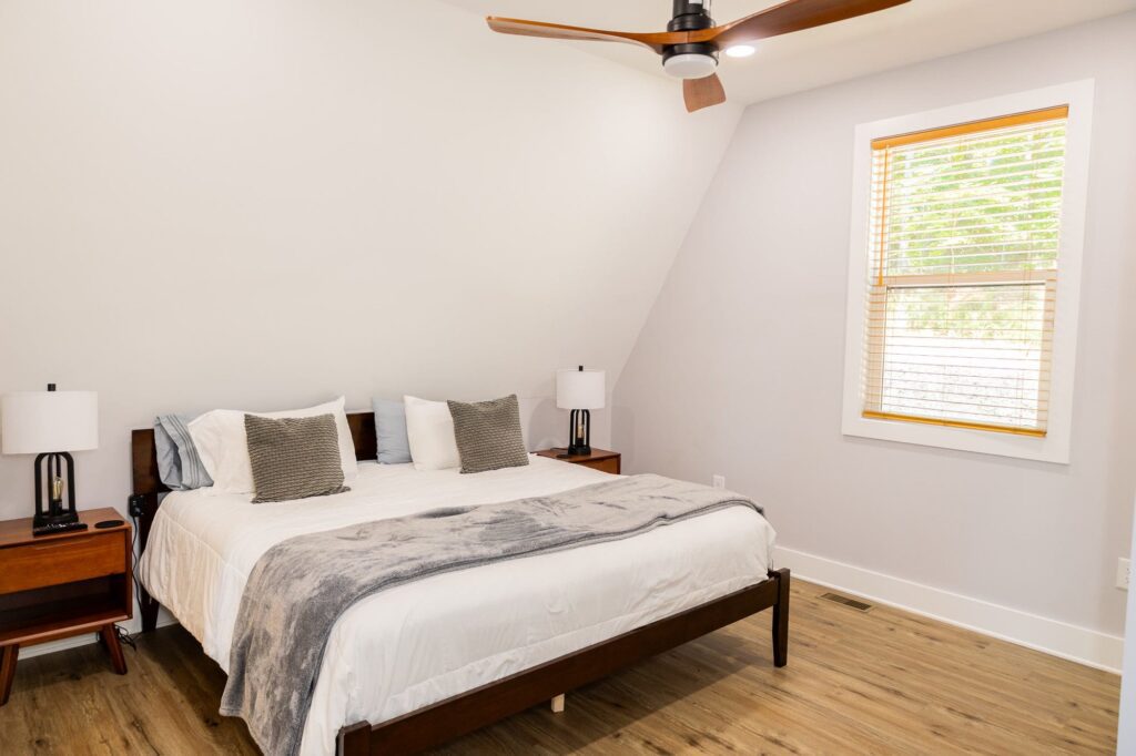 Guest bedroom with a king bed and two windows