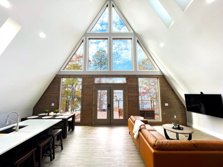 The A-frame living room with its full-height window wall facing the lake